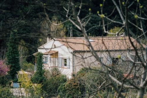 une petite maison blanche avec un toit rouge dans l'établissement Maison d'hôtes éco-responsable avec piscine 6X12m LIRE L'ANNONCE VOTRE HÔTE SVP, à Châteaudouble