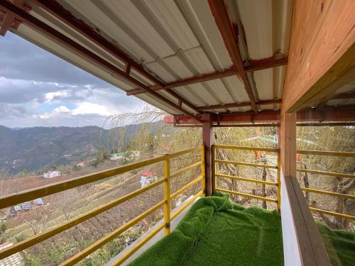 a balcony with a view of a mountain at Lushtree Backpackers - Hostel & Cafe in Mukteswar