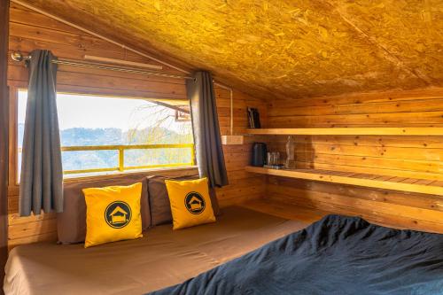 a room with a bed in a log cabin at Lushtree Backpackers - Hostel & Cafe in Mukteswar