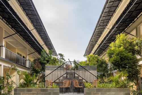 een trap in een gebouw met stoelen en planten bij Cove Kanaya in Seminyak