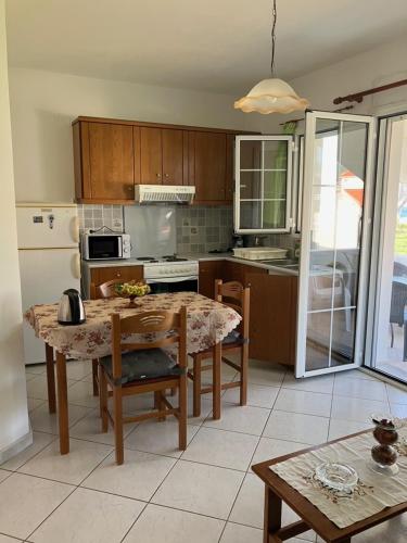 a kitchen with a table and a kitchen with a refrigerator at VOULA'S HOUSES in Karlovasi
