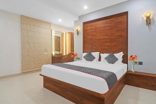 a bedroom with a large bed with a wooden headboard at Super Townhouse 1185 Rcc Pride in Hyderabad