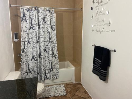 a bathroom with a shower curtain and a toilet at Aqua Studio 6 in Negril