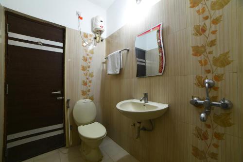 a bathroom with a toilet and a sink at Hitech Shilparamam Guest House in Hyderabad