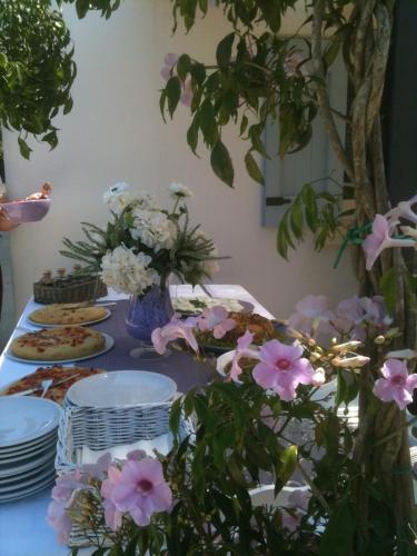 a table with plates and flowers on top of it at Masseria Montelauro in Otranto