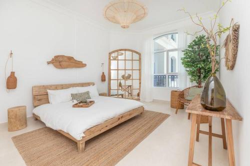 um quarto com uma cama e um vaso sobre uma mesa em Casa Noera, Yas Island 324 em Abu Dhabi