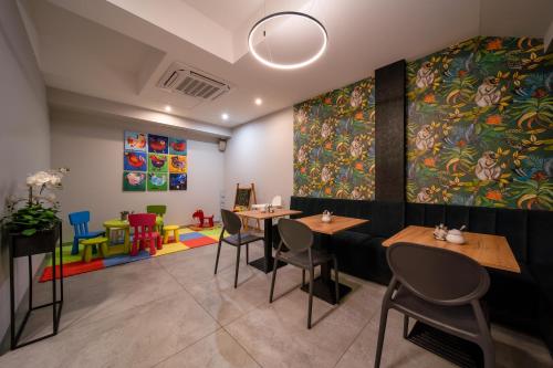 a restaurant with tables and chairs and a large painting at Hotel Alexander in Kraków