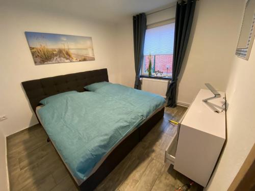 a small bedroom with a bed and a window at Ferienwohnung No 1am Golfplatz in Wiesmoor
