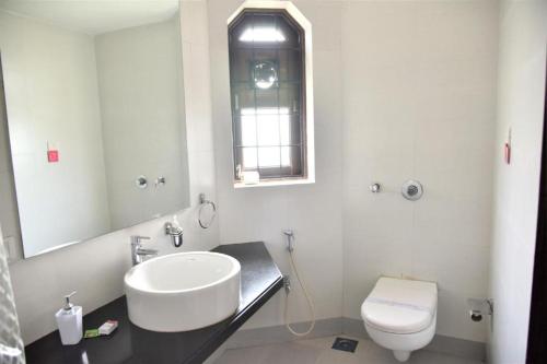 a white bathroom with a sink and a toilet at Hilltop suites by 29 bungalow in Khandāla