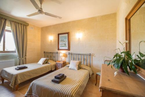 a hotel room with two beds in a room at Ta' Gianni in Xewkija