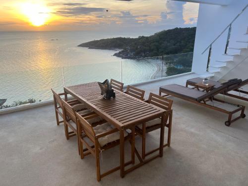 a cat sitting on a wooden table on a balcony at The Beach Residence in Koh Samui 