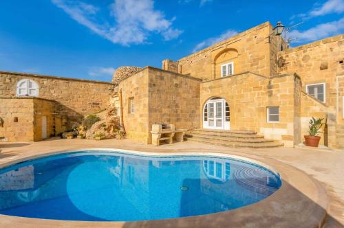 an old stone house with a swimming pool at Gharilma V Holiday Home in Santa Luċija
