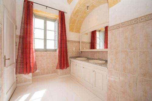 a bathroom with a sink and a red curtain at Ghar Ilma IV Holiday Home in Santa Luċija