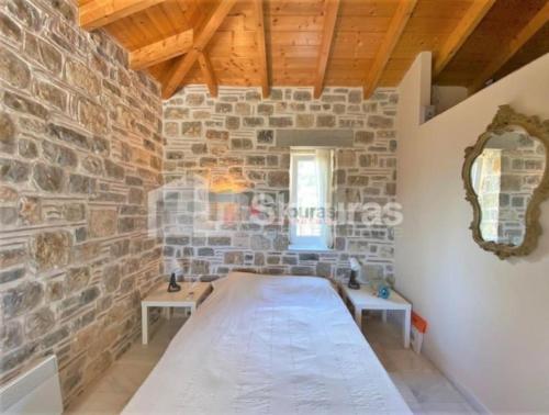 a room with a bed in a brick wall at Villa Katafyki (2 independent houses) in Ermioni