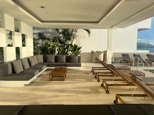 a living room with a couch and tables and chairs at The Beach Residence in Koh Samui 