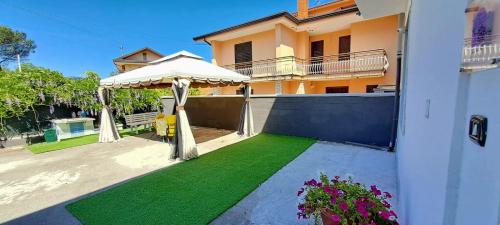una casa con un patio verde con sombrilla en Il Glicine casa vacanze en Avellino