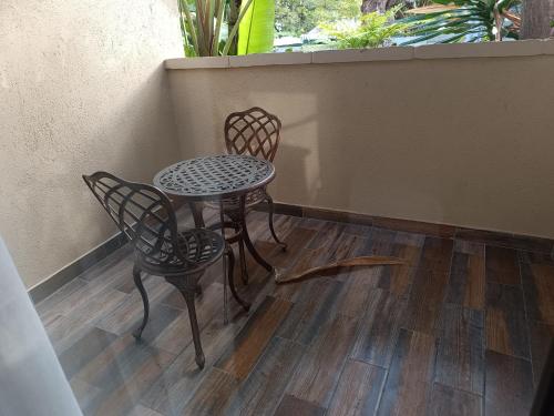 a table and two chairs sitting on a porch at Jacaranda in Harare