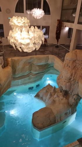 une piscine dans un hôtel avec des rochers dans l'eau dans l'établissement Arcs 1950 Appartement Luxe type chalet 5 à 7 personnes Vue imprenable sur le Montblanc skis aux pieds, à Arc 1950