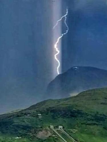a lightning storm in the sky over a hill at Inverlochy Villas (Adults Only) in Fort William