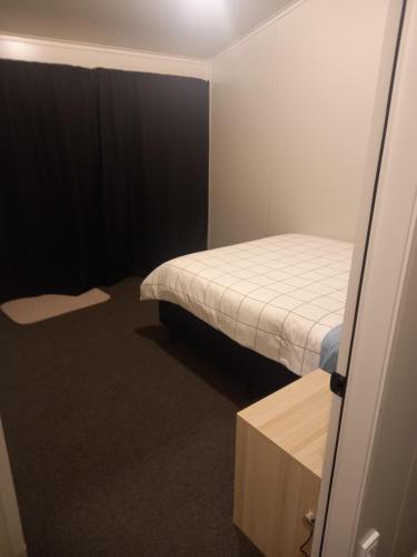 a small room with a bed and a table at Rimu in Ohakune