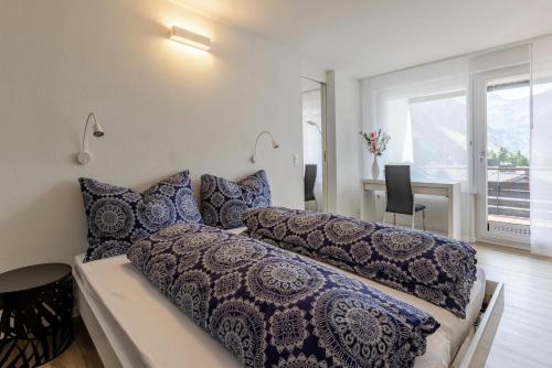 a bedroom with a bed with blue pillows at Alexandra 513 in Arosa