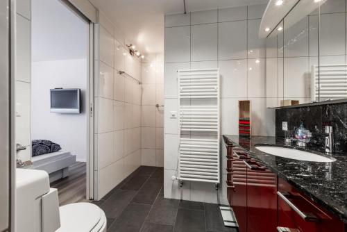 a bathroom with a toilet and a sink and a shower at Alexandra 513 in Arosa
