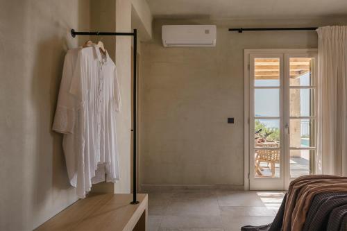 a room with a robe hanging on a wall at Uberina - Olea Di Assos Villas in Asos