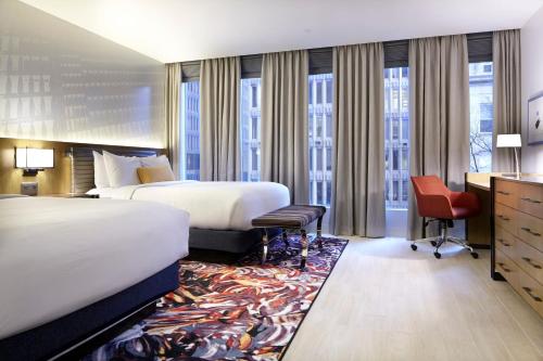 a hotel room with two beds and a desk at Hotel Indigo Atlanta Downtown by IHG in Atlanta