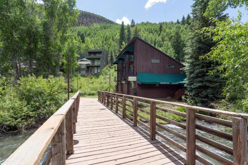 a wooden bridge over a river with a building at Manitou Lodge 5 Hotel Room in Telluride