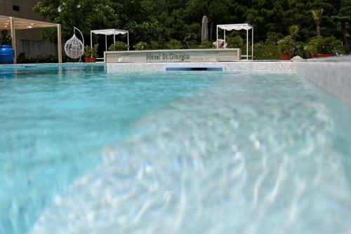 a large swimming pool with blue water at Hotel St. Giorgio in Castel San Giorgio