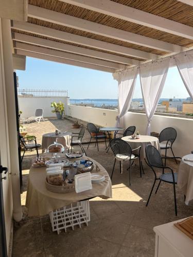 a patio with tables and chairs on a roof at Palazzo Angelelli in Gallipoli