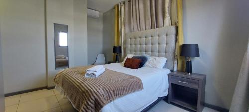 a bedroom with a large white bed and a window at Bee's Central Hideout in Windhoek