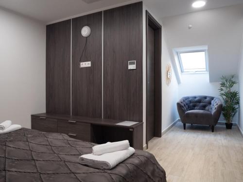 a bedroom with a bed with a desk and a chair at Andoravendégház - Villány in Villány