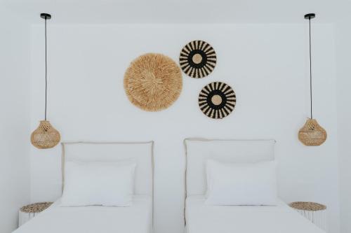 a room with two beds and two pendant lights at Pili Pala Suites in Episkopianá