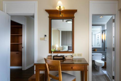 a bathroom with a desk with a mirror and a toilet at Kantary Bay Hotel And Serviced Apartment Rayong in Rayong
