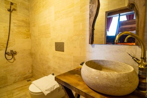 a bathroom with a stone sink and a toilet at Cappadocia Snora Cave in Nevsehir