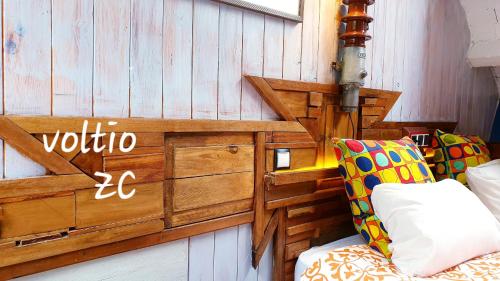 Cette chambre dispose d'un canapé et d'un mur en bois. dans l'établissement zentral club voltio-jacuzzi, à Belmonte de Miranda