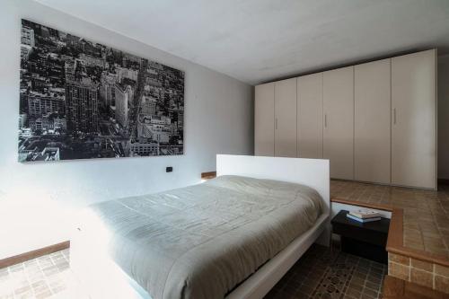 een slaapkamer met een bed en een schilderij aan de muur bij Sun Luxury Apartment with Swimming Pool - Blevio in Blevio