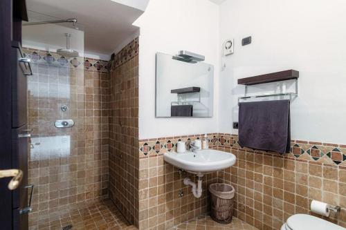 a bathroom with a sink and a toilet and a mirror at Sun Luxury Apartment with Swimming Pool - Blevio in Blevio