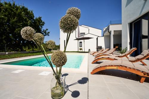 a vase with flowers in it next to a pool at Villa Martin Noel in Poreč