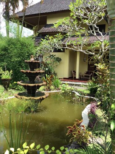 a garden with a pond in front of a house at Gerebig Bungalow in Ubud