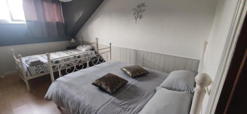 a bedroom with two beds and a window at gîte résidence de la fontaine à Compreignac in Compreignac