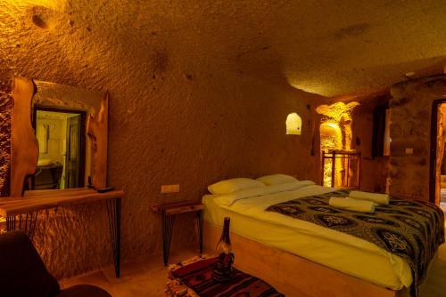 a bedroom with a bed and a mirror in a room at Cappadocia Snora Cave in Nevsehir