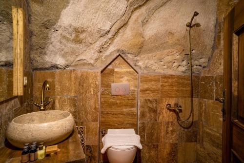 a stone bathroom with a sink and a toilet at Cappadocia Snora Cave in Nevsehir
