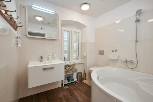 a white bathroom with a tub and a sink at Apartment San Pietro in Cavtat