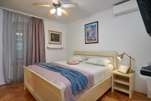 a bedroom with a bed and a ceiling fan at Apartment San Pietro in Cavtat