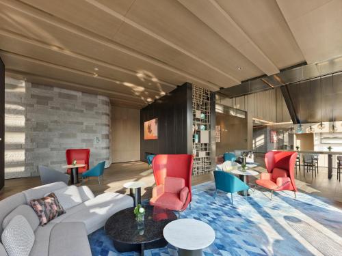 a lobby with red and blue chairs and tables at Dhawa Xi'an Chanba in Xi'an