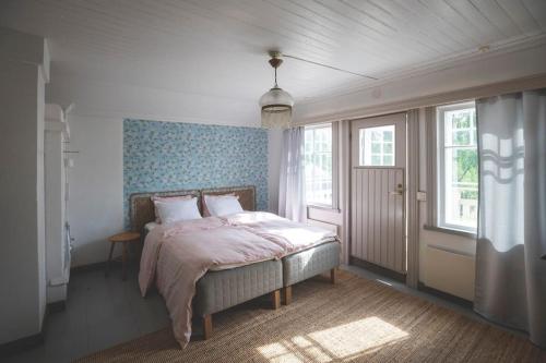 a bedroom with a bed in a room with windows at Kotoisa asunto Museon pihapiirissä Rautalammilla in Rautalampi