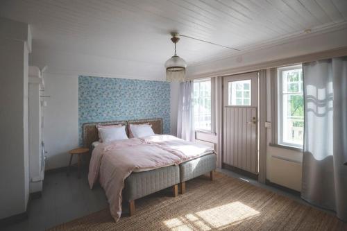 1 dormitorio con 1 cama en una habitación con ventanas en Kotoisa asunto Museon pihapiirissä Rautalammilla, en Rautalampi