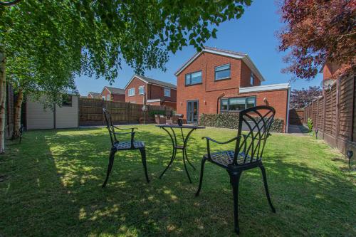 dos sillas y una mesa en el patio de una casa en Styche View, beautiful 4 bedroom home available, en Market Drayton